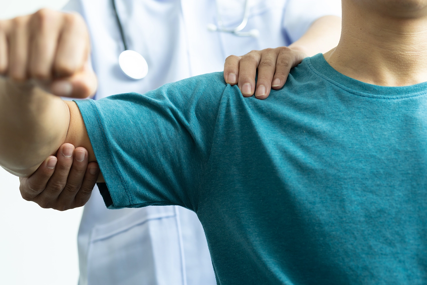 A medical professional assessing a patient’s shoulder pain