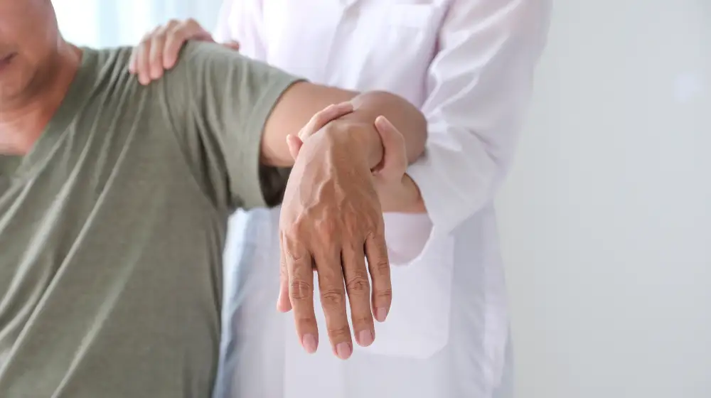 Orthopaedic specialist assessing a patient’s shoulder in a physical examination.