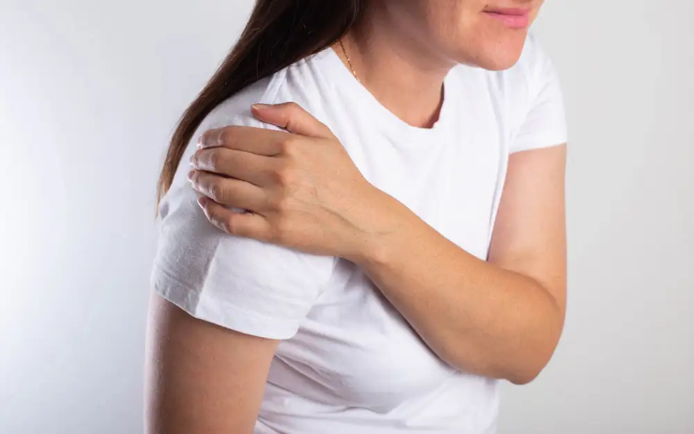 Woman with rotator cuff tear, hand on shoulder.